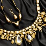 czarna sukienka a obok niej złota biżuteria